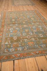Angled view of a vintage Mehreban rug's geometric Herati design in sky blue and terracotta.