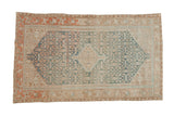 Distressed Persian Malayer rug with a central diamond medallion and quatrefoil patterns in blue, sand, and red.