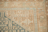Corner detail of a vintage Malayer rug showing geometric borders in sky blue, sand, and ivory.