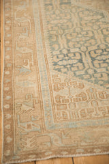 Low, hand-knotted pile and geometric borders in sand and sky blue on a vintage Persian Malayer rug.