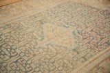 Textured wear across knot heads on a distressed Malayer rug with sky blue and sand floral details.