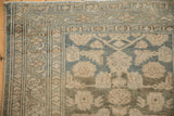 Detail of the distressed Malayer runner's border showing low pile and meandering vine design.