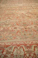 Low-angle view showing the textured, worn pile and soft tones of a vintage Malayer carpet.