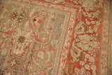 Corner detail of a vintage Malayer carpet showing the red palmette border and worn silver field.
