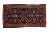Vintage Mehreban rug with allover palmettes and leaves in red and blue on a deep navy ground.