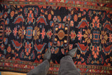 A vintage Mehreban rug's large palmettes in rich red and blue on a navy ground.