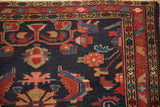 Close-up on the intricate floral and serpent-design borders of a vintage Persian Mehreban rug.