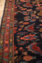 Intricate serpent and floral borders of a vintage Mehreban rug with a deep navy blue pile.