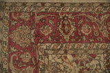 Corner view of the floral arabesque and blossom design in the raspberry red border of a Sivas carpet.