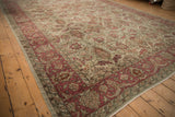 Angled perspective of a vintage Sivas carpet showing its raspberry red floral border and low pile.