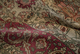 Low pile texture of a vintage Sivas carpet showing knot heads and raspberry floral details.