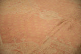 Distressed rose and pale gold field of a vintage Oushak rug, with curvilinear details.