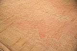 Faded rose, dusty blush, and pale gold distressed Oushak carpet with worn floral patterns.