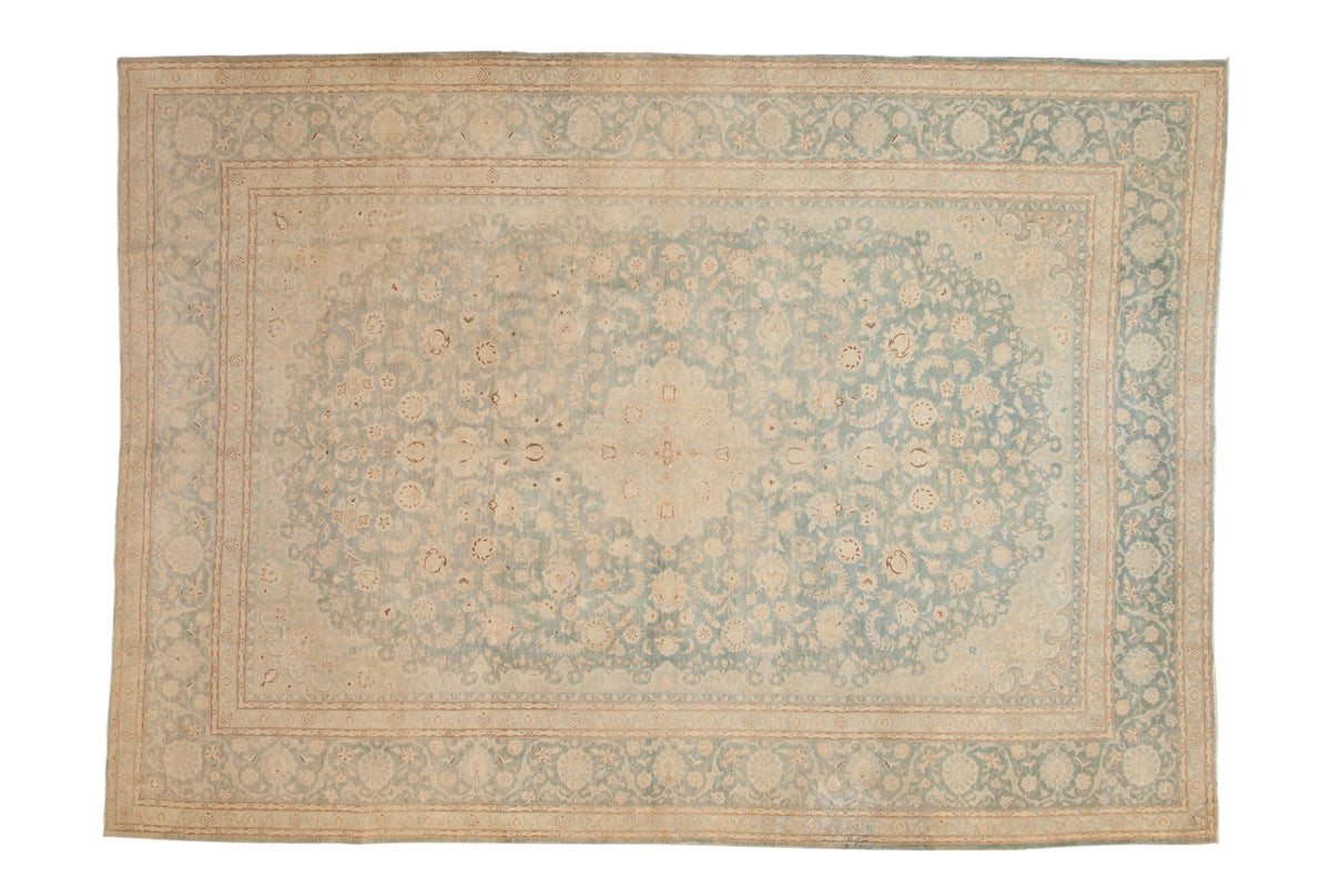 Distressed Persian Kashan rug with a central medallion and floral field in pale sky blue and muted silver tones.