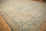 Even wear across the stylized arabesque vine border of a vintage distressed Kashan carpet.