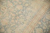 Sky blue floral field meets the slim border on a distressed vintage Kashan carpet.