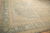 Low-pile texture and vine border on a distressed Kashan carpet corner in pale blue and beige.