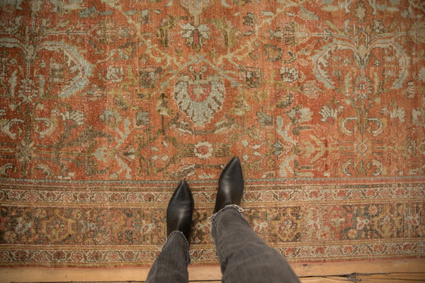 A downward view showing the worn, low pile and floral pattern of a vintage Mahal carpet.