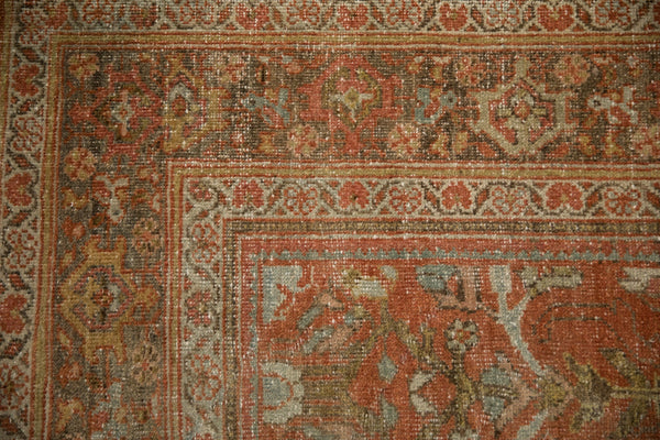Corner detail of a vintage Mahal carpet showing the floral border and distressed low-pile texture.