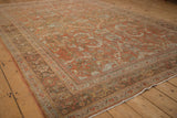 Angled view of a vintage Mahal carpet highlighting its distressed low pile and madder root red tones.