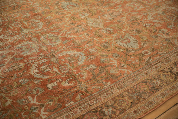 Angled detail of the distressed hand-knotted pile and floral pattern on a vintage Mahal carpet.