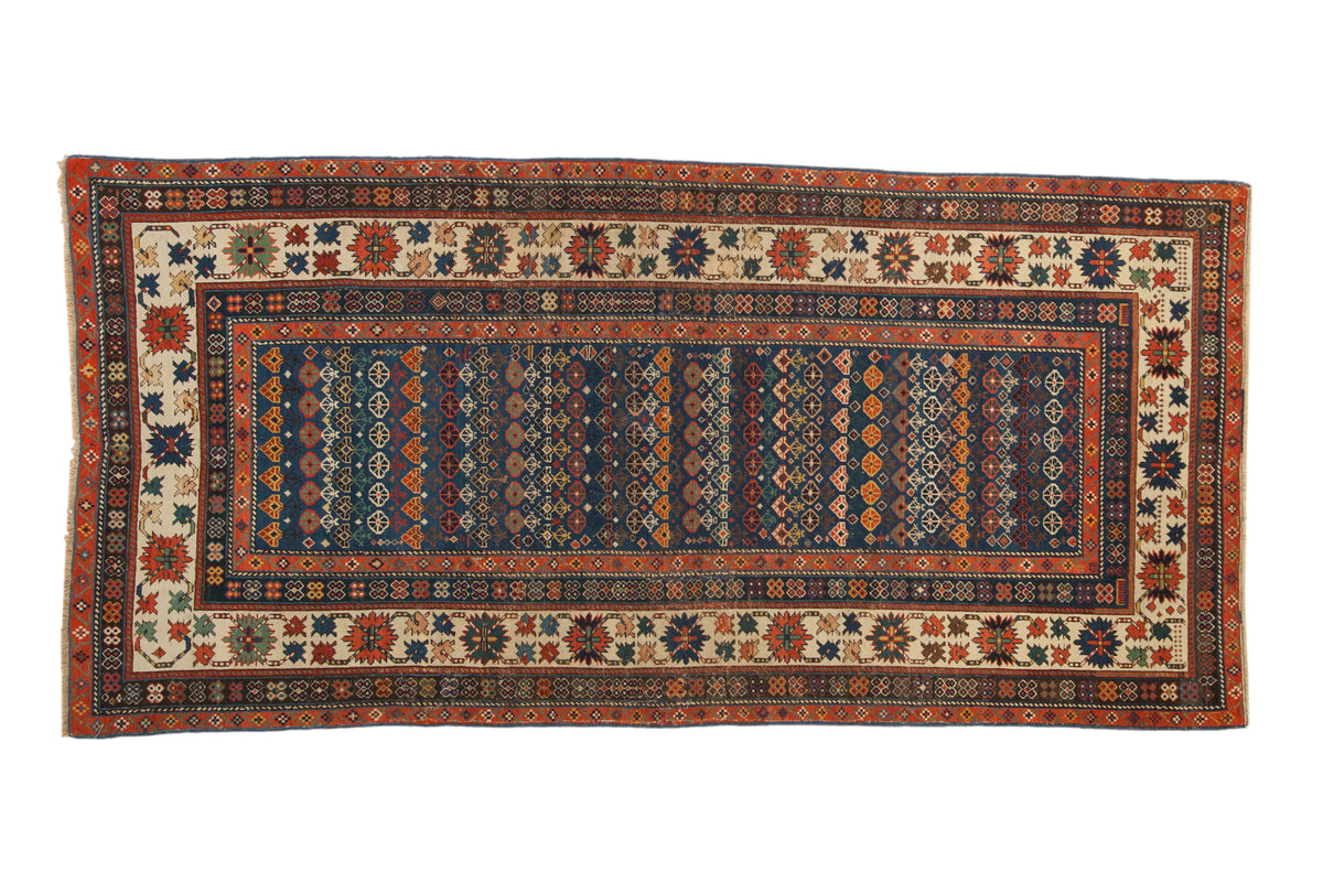 Antique Caucasian runner with sapphire blue field, rowed floral patterns, and a vibrant crab-style border.