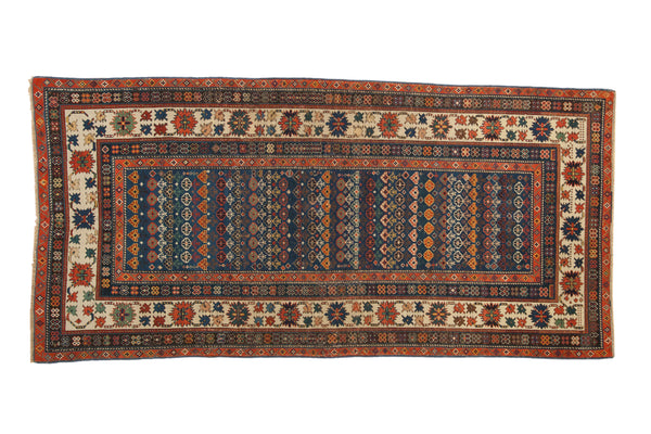 Antique Caucasian runner with sapphire blue field, rowed floral patterns, and a vibrant crab-style border.
