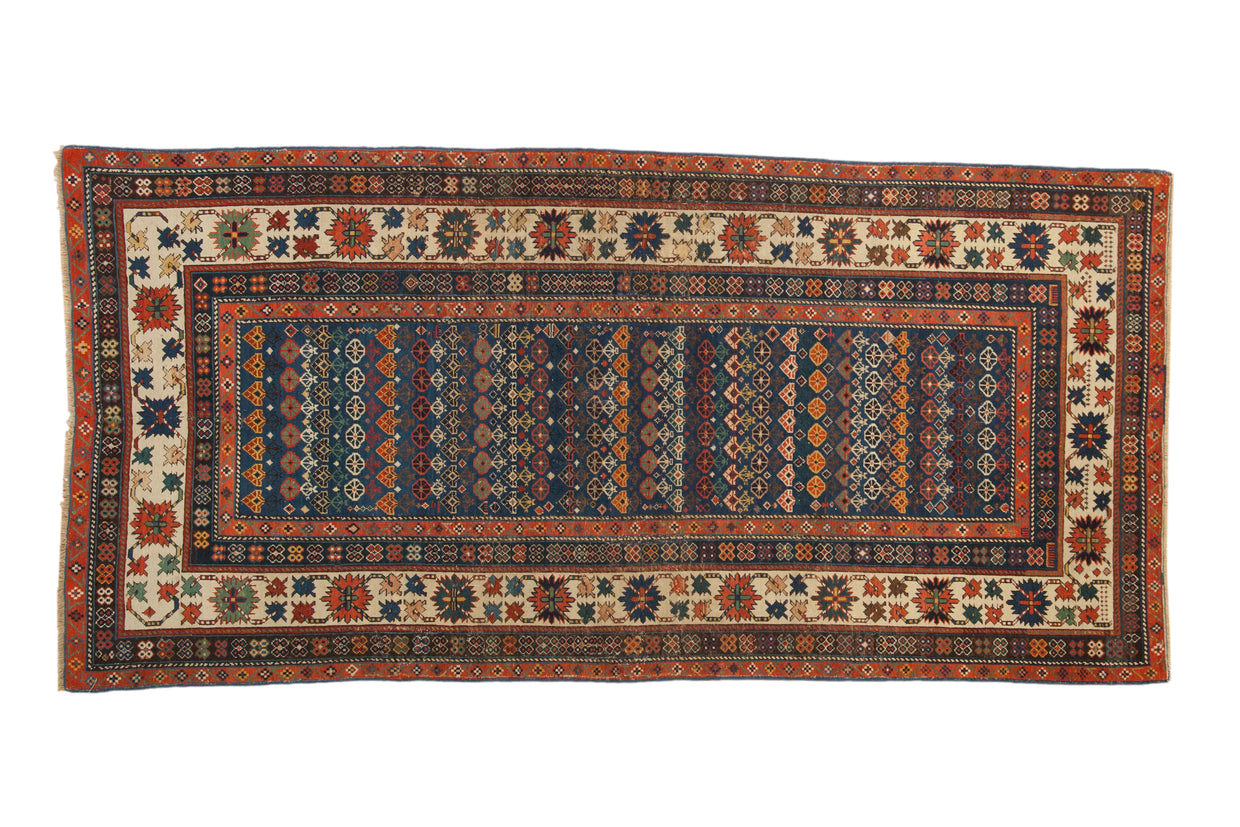 Antique Caucasian runner with sapphire blue field, rowed floral patterns, and a vibrant crab-style border.