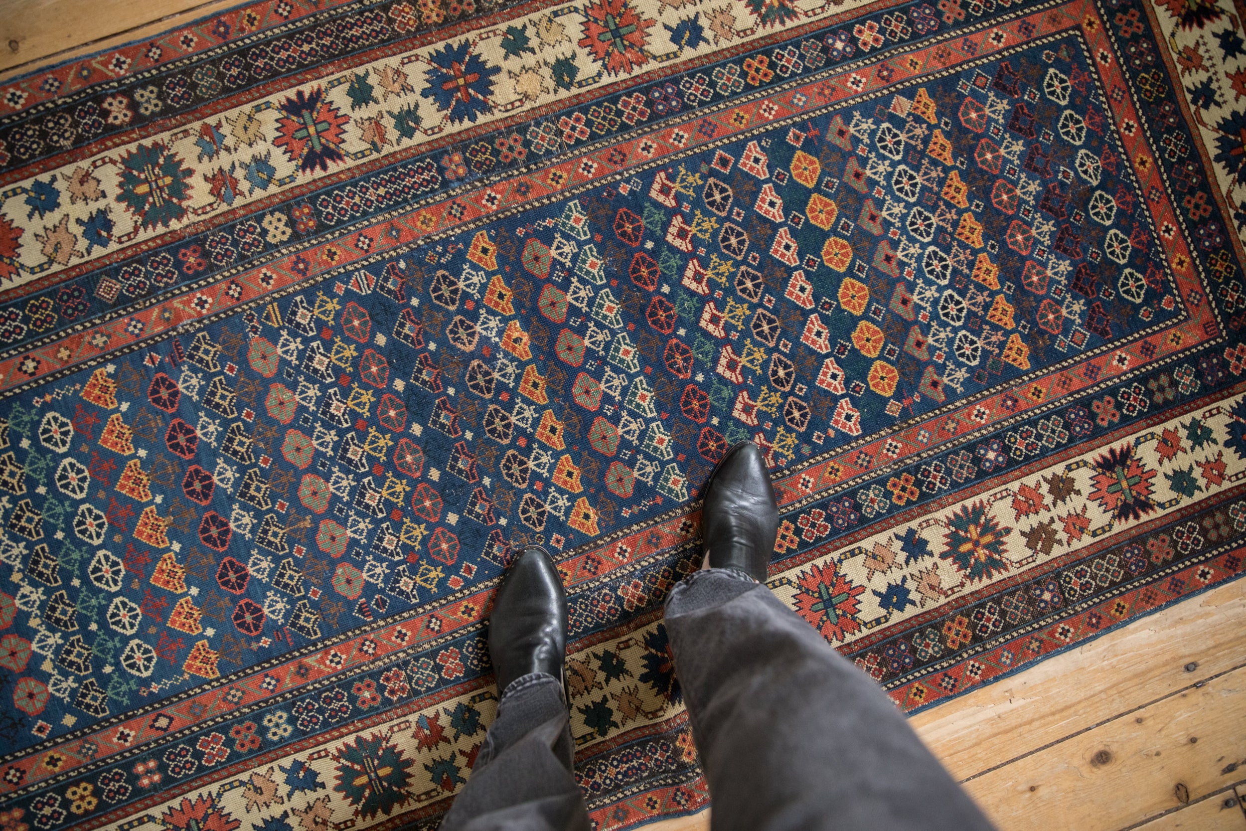 Antique Caucasian rug section, sapphire blue field with geometric flora and a madder root crab border.