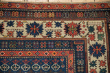 Antique Caucasian rug corner, featuring crab border and ivory field with sapphire floral motifs.