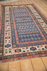 Sapphire blue field with germinating plant motifs and ivory crab border of antique Caucasian rug.