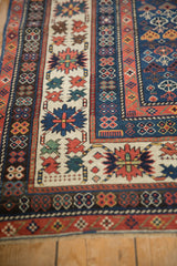 Antique Caucasian rug corner displaying geometric crab style border and ivory floral field.