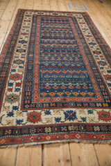 Antique Caucasian rug: ivory crab style border, sapphire blue field with floral motifs.