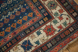 Antique Caucasian rug corner: sapphire blue field with plant motifs, madder red crab border.