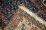 Antique Caucasian rug's hand-knotted back weave, natural fringe, and blue side cord.