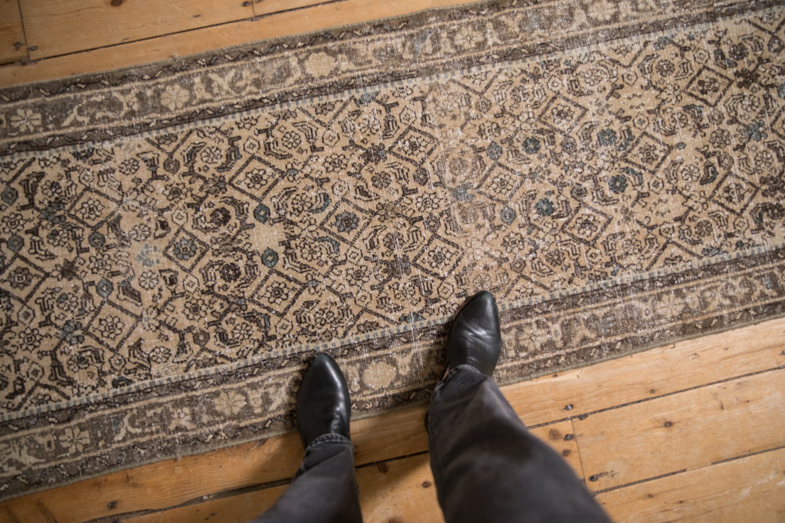 Beige and charcoal Herati pattern on a distressed Hamadan runner with time-softened border.