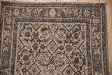 Distressed Hamadan rug runner with worn Herati pattern, arabesque border, and visible foundation.