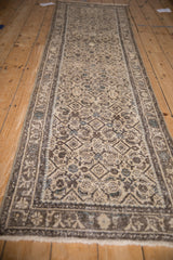 Worn Herati field and arabesque border of a distressed Hamadan runner in beige, charcoal, blue.