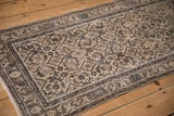 Close-up of distressed Hamadan runner with beige Herati pattern, time-softened charcoal border, and dusty blue accents.