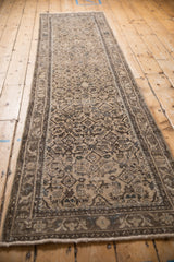 Distressed vintage Hamadan runner showing arabesque border, Herati pattern, and worn pile.