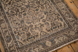 Distressed vintage Persian Hamadan runner corner with worn beige Herati motif and arabesque border.