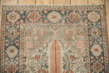 Distressed vintage Bakhtiari runner: visible foundation, tangerine, charcoal, and ivory floral pattern.
