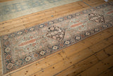 Distressed Bakhtiari runner featuring cypress tree motif and floral designs in tangerine, ivory, and cobalt.