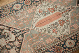 Geometric ivory medallion with tangerine floral details on distressed Bakhtiari rug.