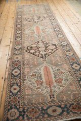 Distressed Bakhtiari rug runner's ivory medallion with tangerine cypress tree and cobalt blue border.