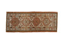 Distressed vintage Serab runner with geometric medallions in ivory, madder red, and pale blue.