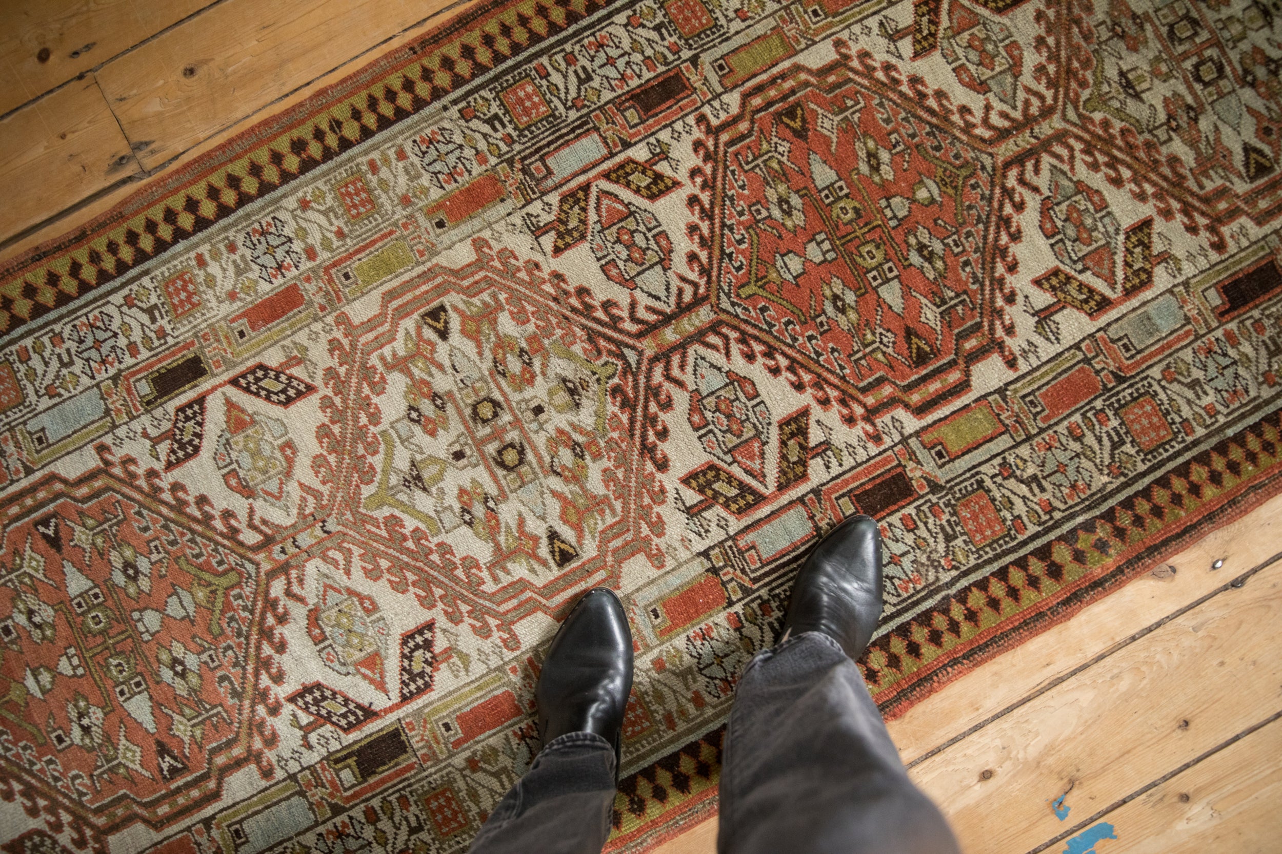 Distressed Serab runner's textured pile, geometric bouquets, madder root red, and ivory.