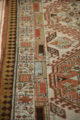 Distressed Serab runner showing geometric pawn border, meandering vine, and low pile texture.