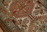Hooked geometric patterns and angular leaves on a distressed Serab runner in red, ivory, green.