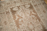 Distressed vintage Hamadan runner showing geometric primitive plant motifs and abrashed brown tones.